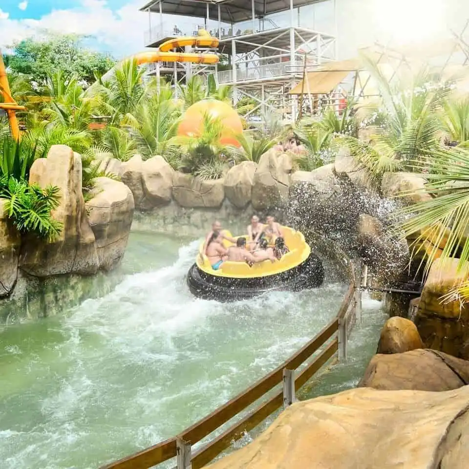 Grupo de amigos sorrindo e se divertindo próximos à água no Thermas